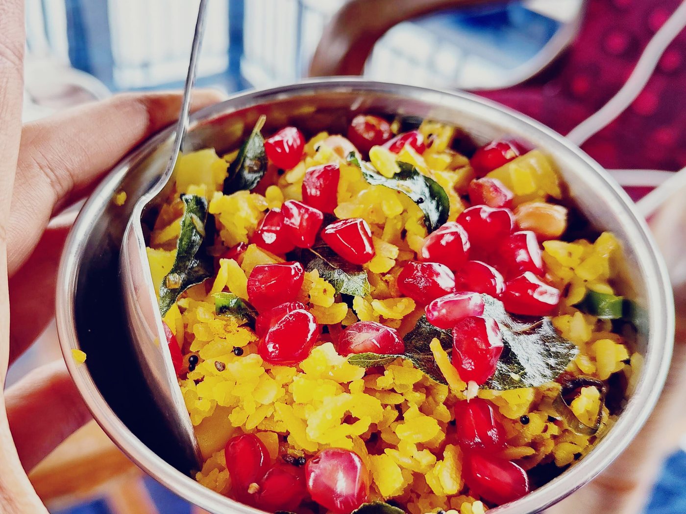 Breakfast poha with pomegranate and curry leaves, eaten on the balcony