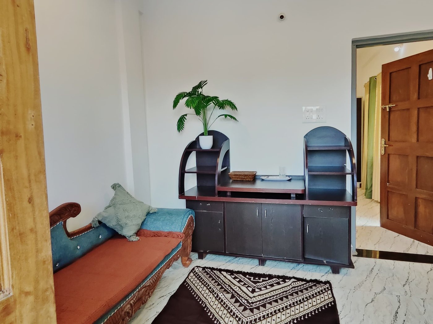 Coconut room: carved daybed, writing desk and kilim rug