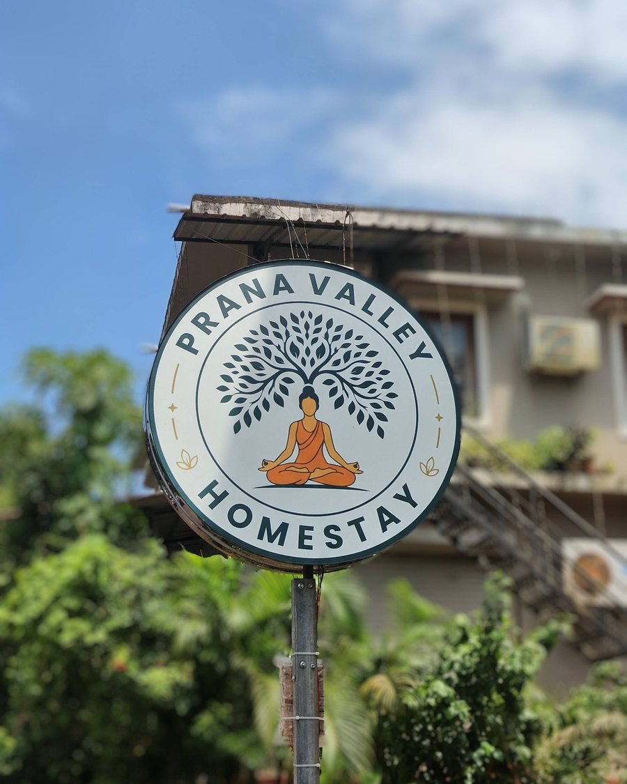 The round Prana Valley Homestay sign at the gate